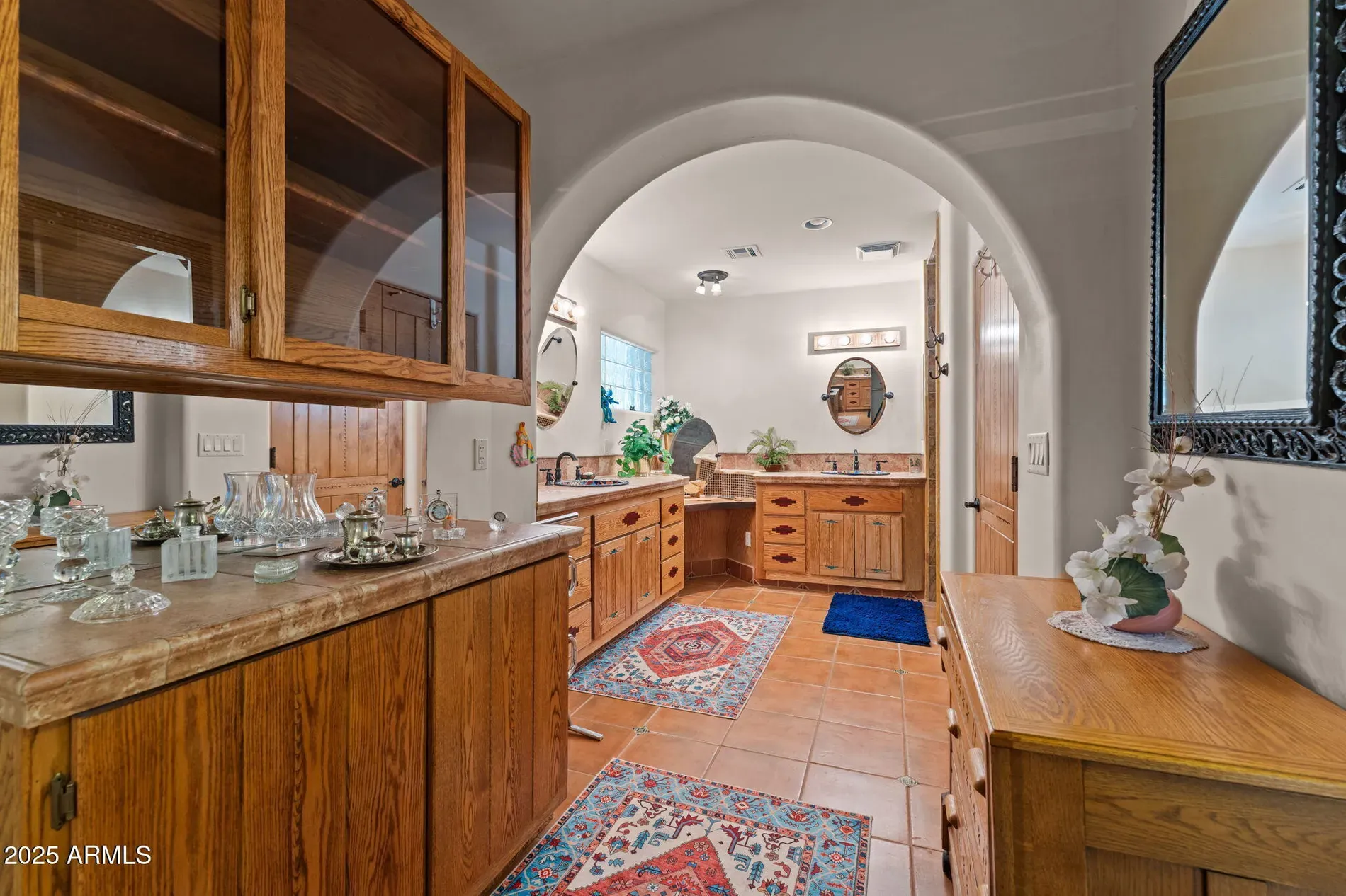 Arched doorway into the bath, honey wood cabinets, pretty cozy.