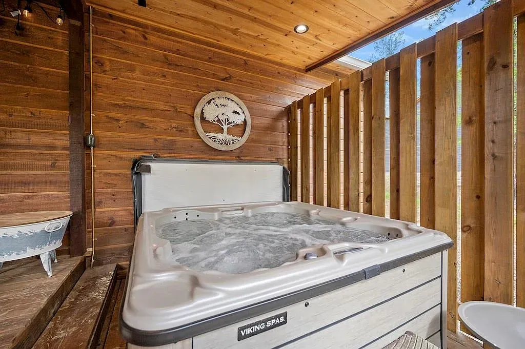 Hot tub tucked into a dark wood nook. Instant cabin retreat.