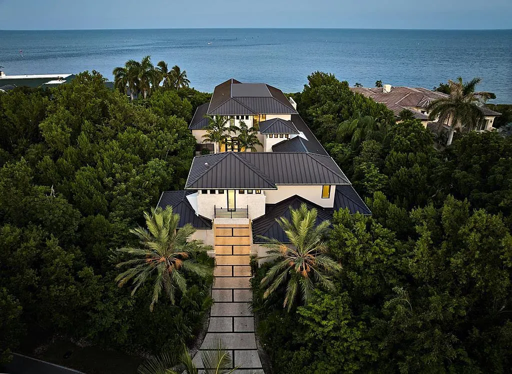 Coastal facade in light tones tucked into greenery. Clean lines, very calm.