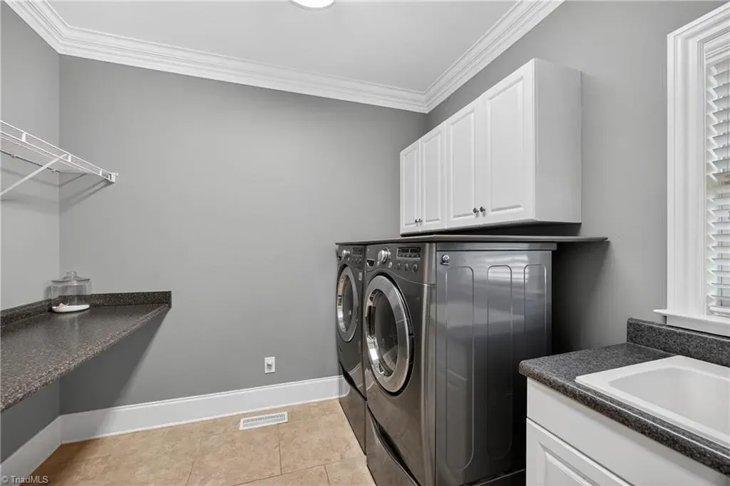 Laundry that looks calmer than my brain. Gray walls, shiny machines, big counter.