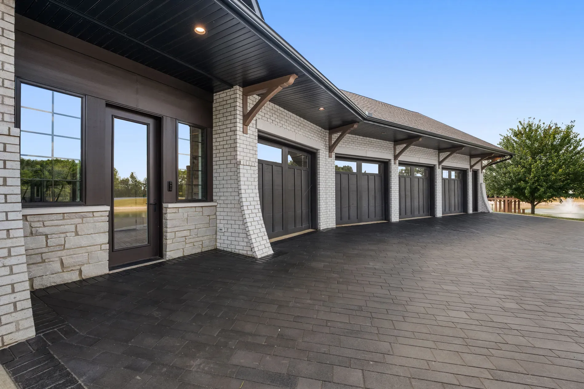 Garage glow-up. light brick, dark wood accents, slatted doors looking sharp.