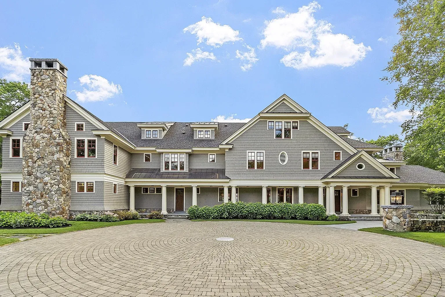 Another exterior angle—gray and stone, big windows doing the symmetry thing.
