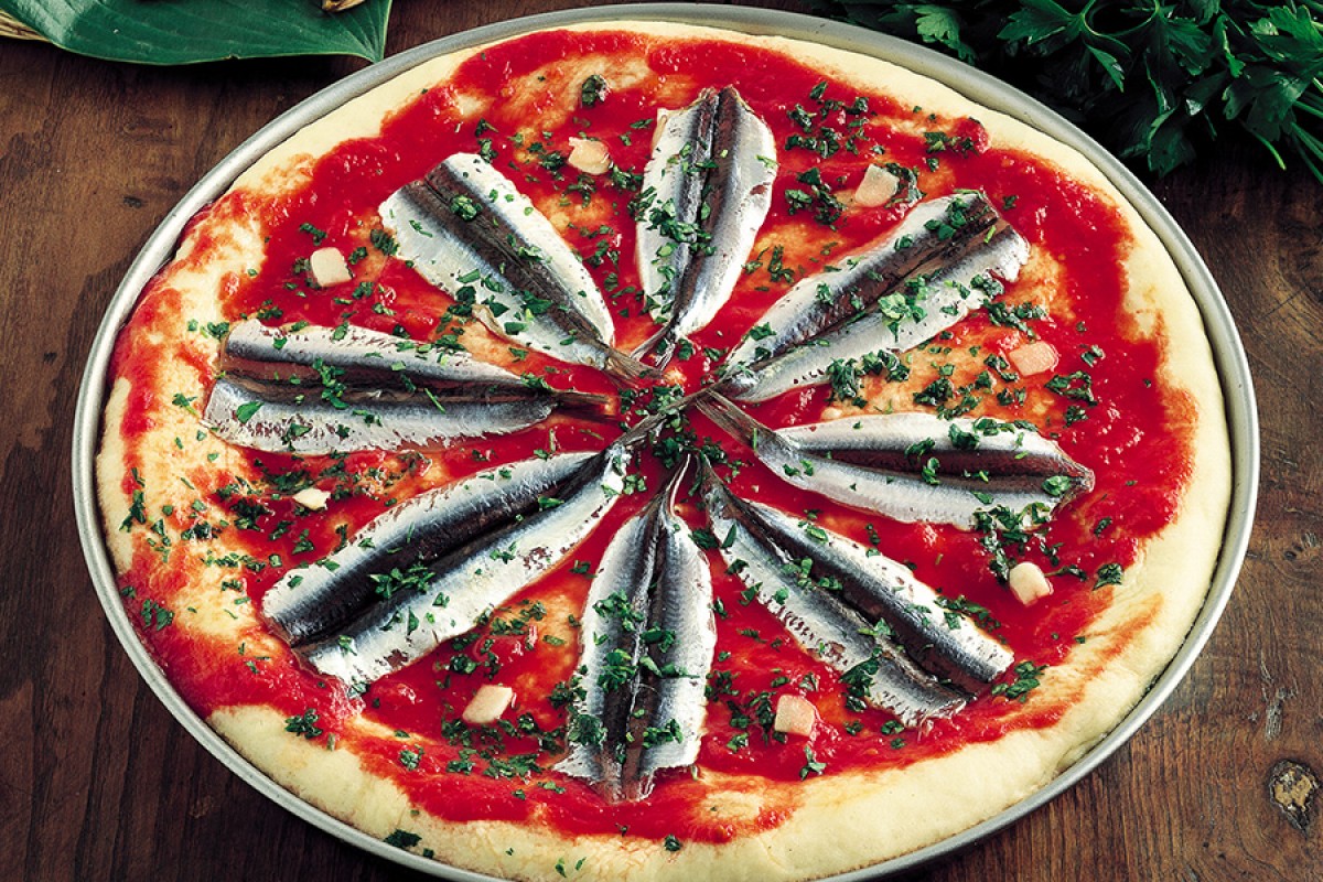 a freshly baked pizza with anchovies
