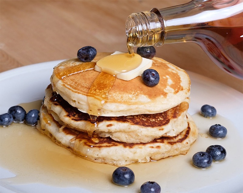 a fluffy stack of pancakes with New Hampshire maple syrup