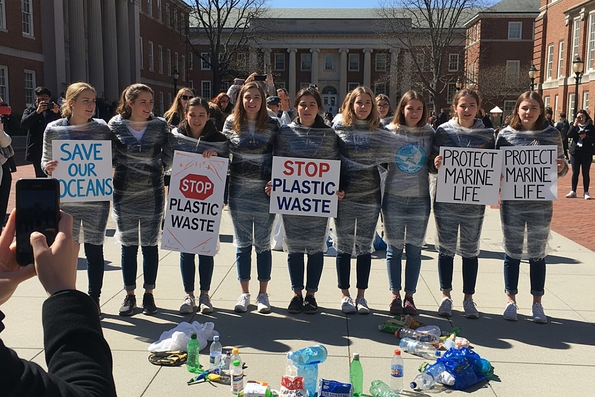 Close-up of student activist wrapped in plastic with concerned expression