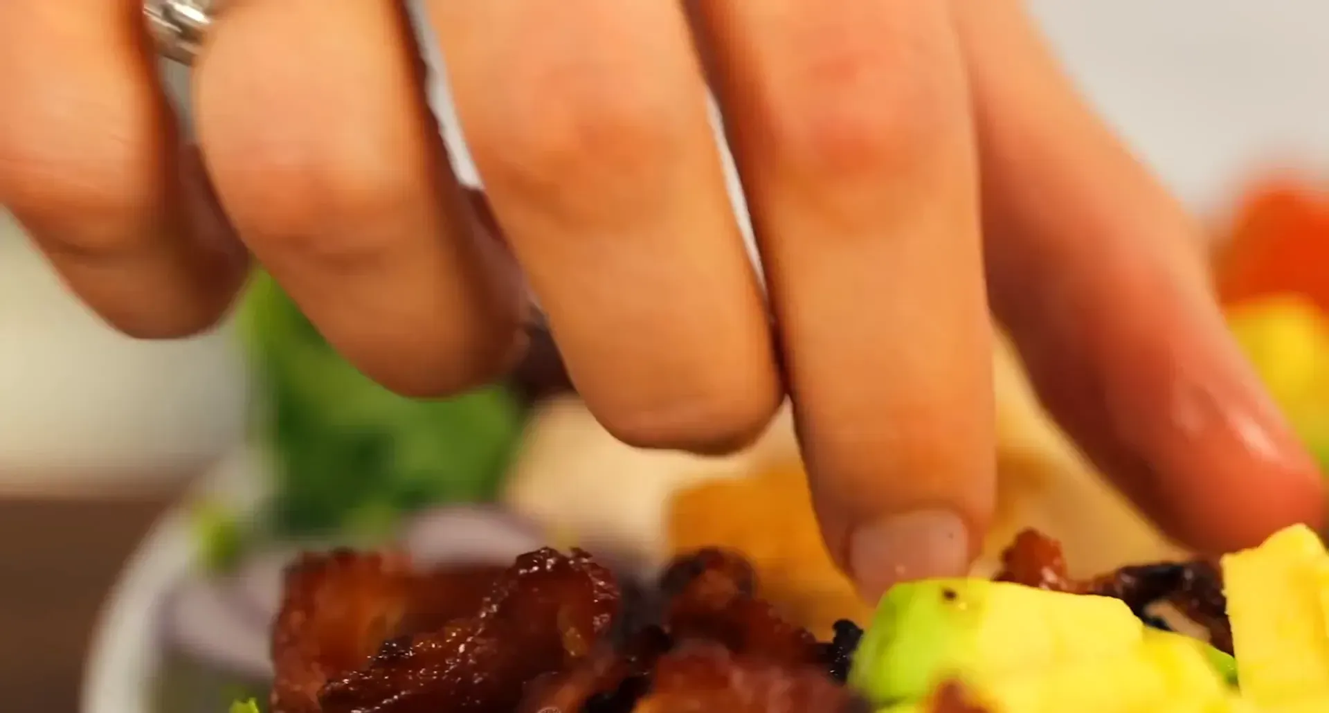 Adding bacon to the salad.