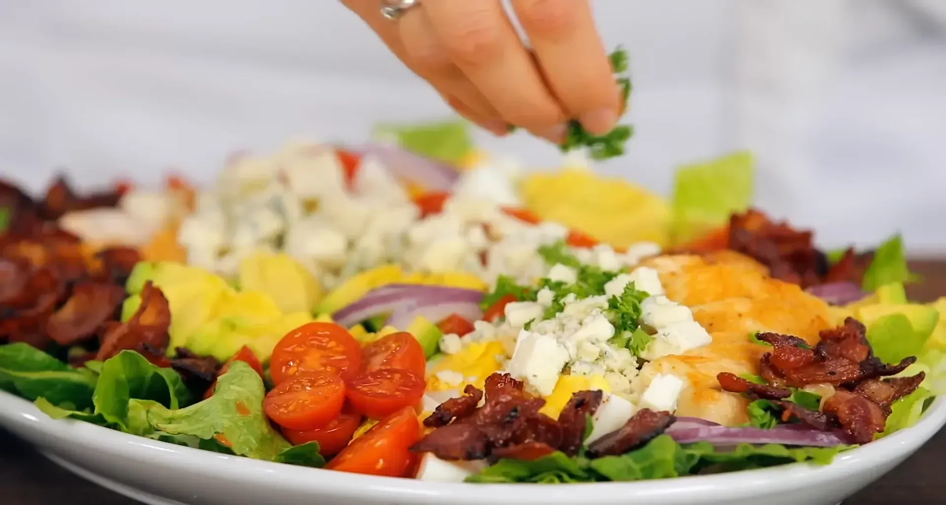 Garnishing the salad with parsley.