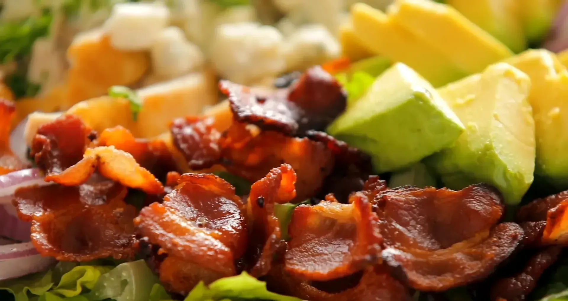 Sprinkling blue cheese on the salad.