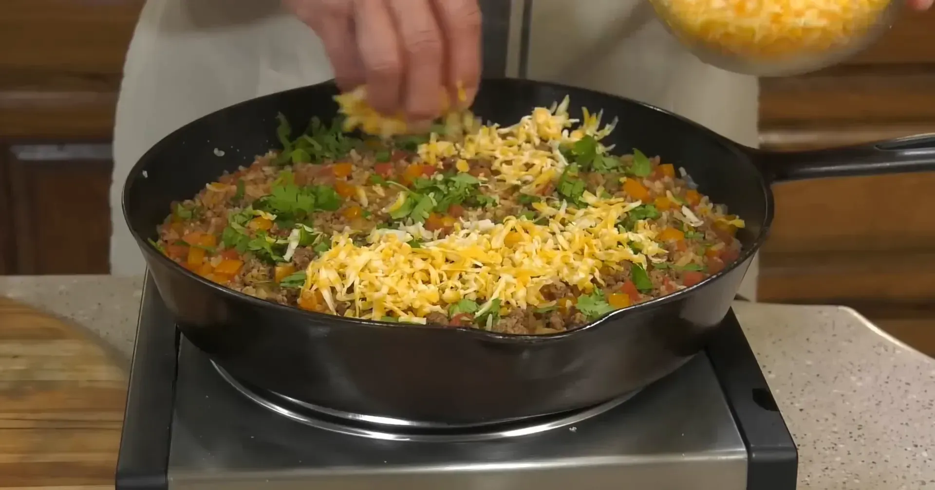 Adding cheese and cilantro to the skillet