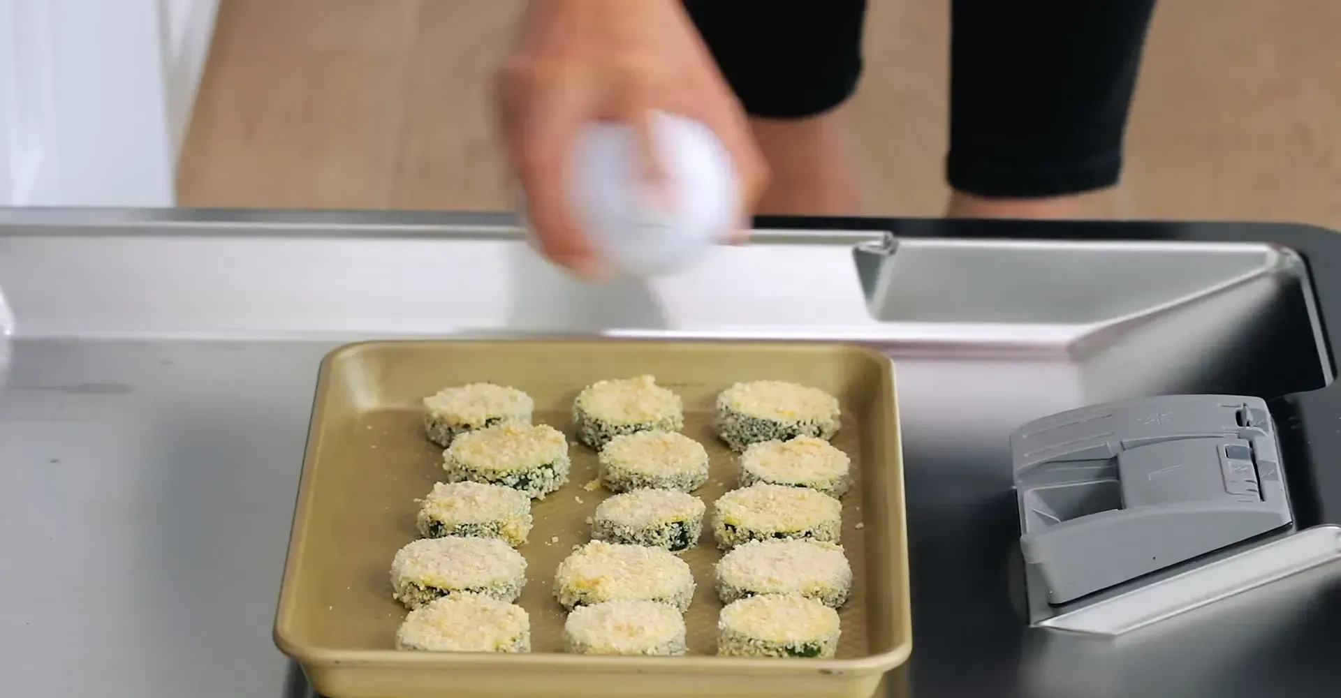 Spraying zucchini with cooking spray for baking.