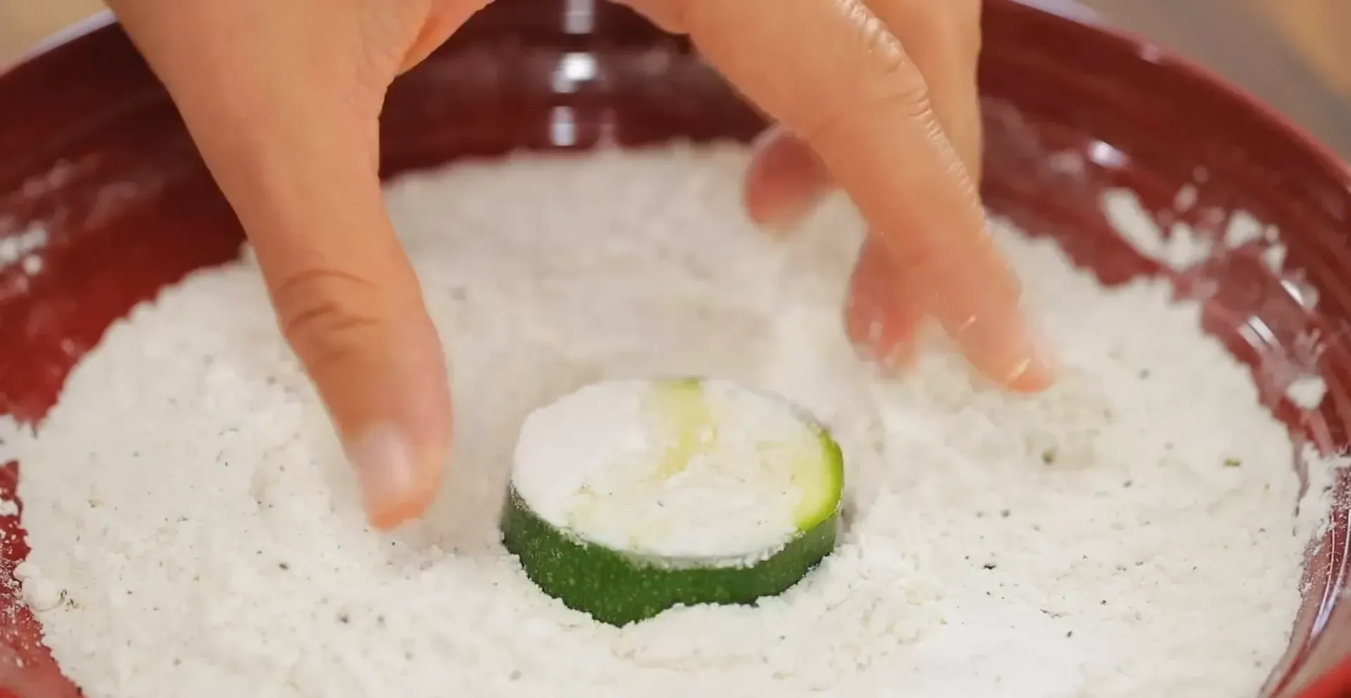 Dredging zucchini in flour.