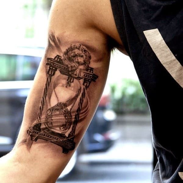 a masculine upper arm tattoo with hourglass
