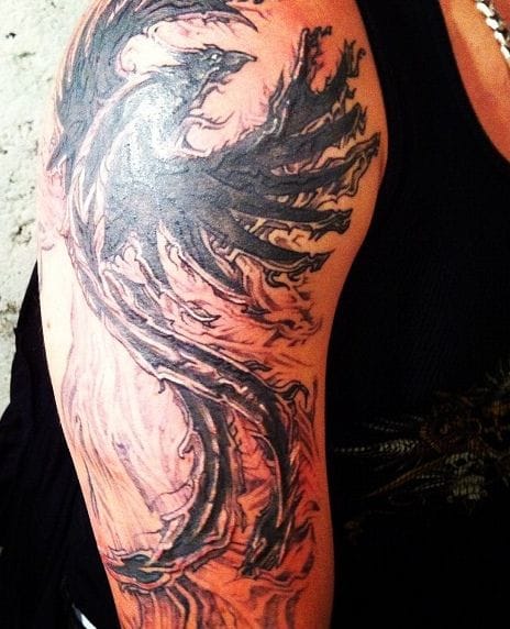 an upper arm tattoo with a phoenix