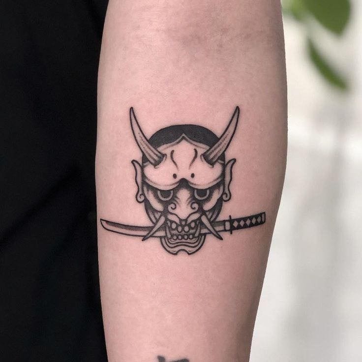 a small Japanese tattoo with Oni mask