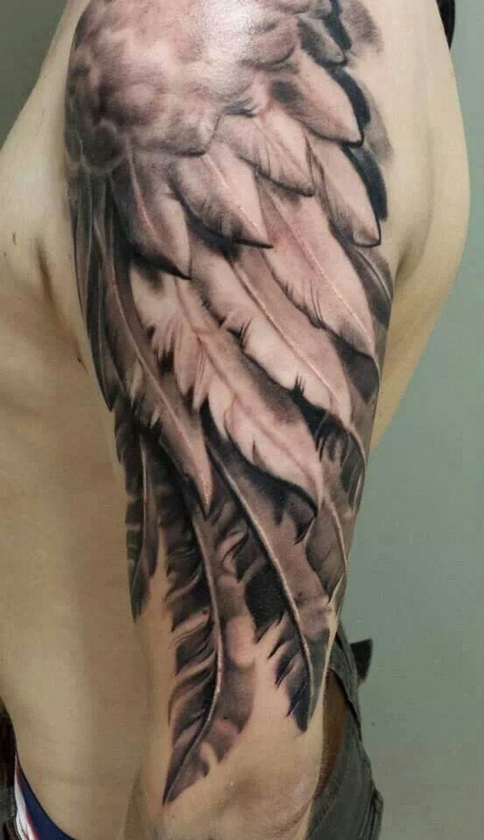 an upper arm tattoo with a feather