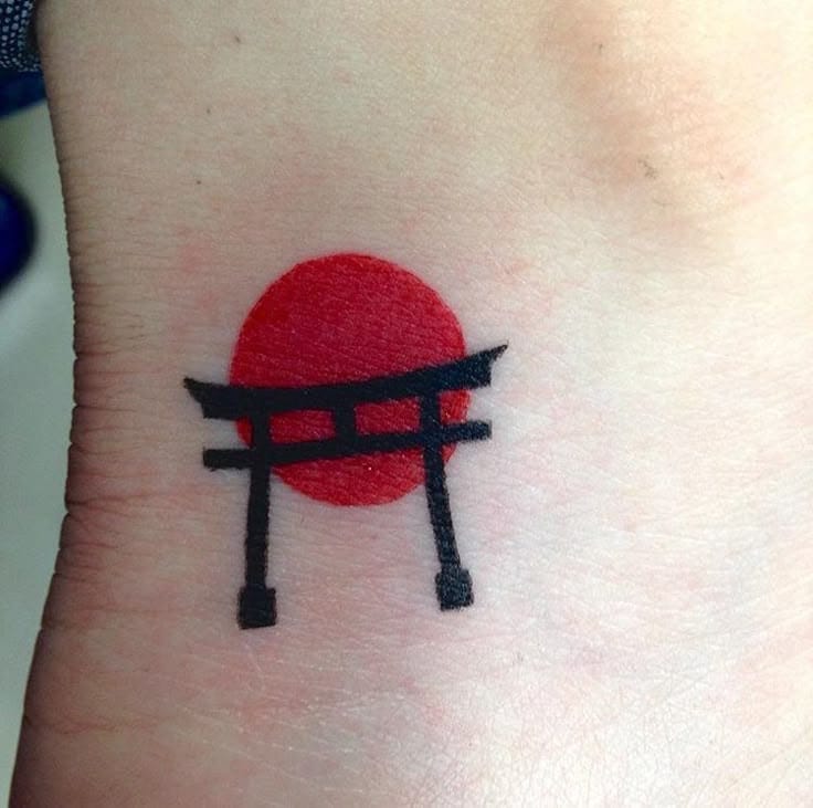 a small Japanese tattoo with a Torii gate