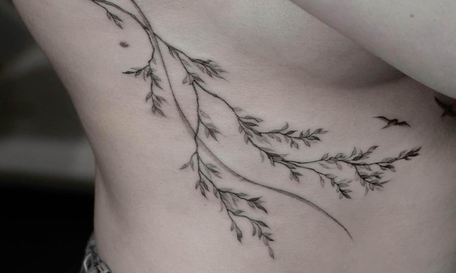 a ribs tattoo with a floral branch