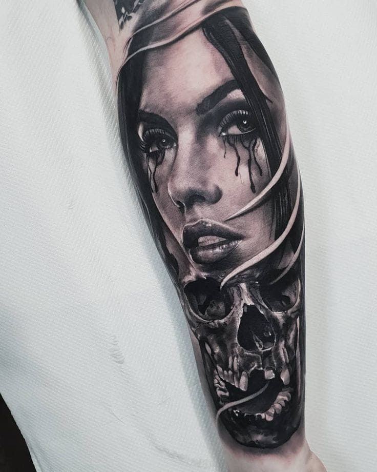upper arm with detailed black and grey portrait tattoo