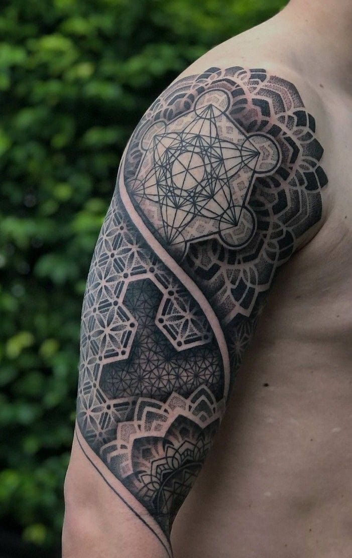 a tattooed man's upper arm with geometric sleeve