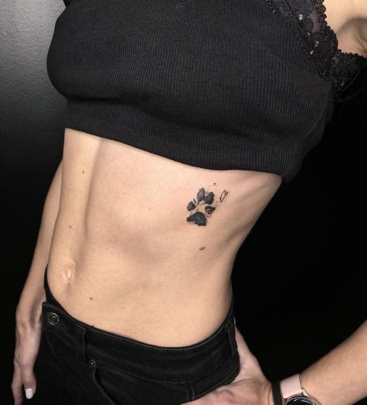 a rib tattoo with a paw print and heart
