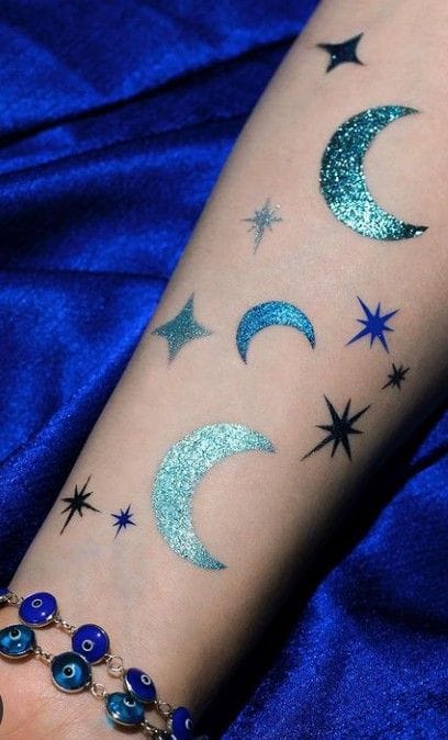 a dazzling glitter tattoo with a crescent moon