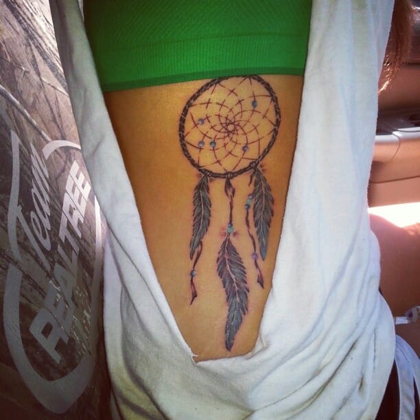 a rib tattoo with a dream catcher