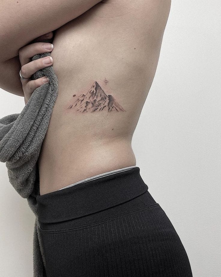a ribs tattoo with mountain range outline