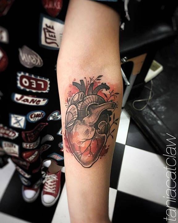 upper arm with anatomical heart tattoo in detailed style