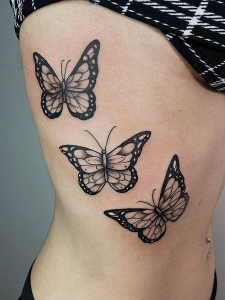 a ribs tattoo with a detailed butterfly