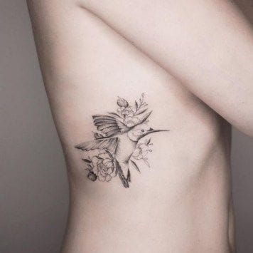 a ribs tattoo with a hummingbird in flight