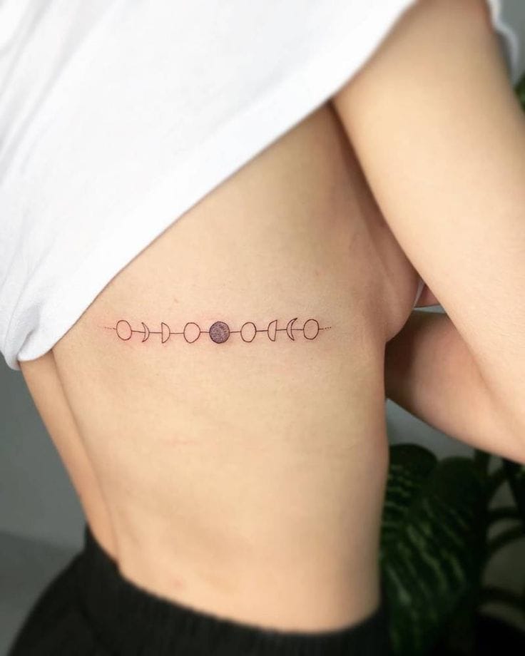 a ribs tattoo with a celestial moon phase