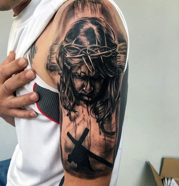 a muscular upper arm tattoo with religious icon