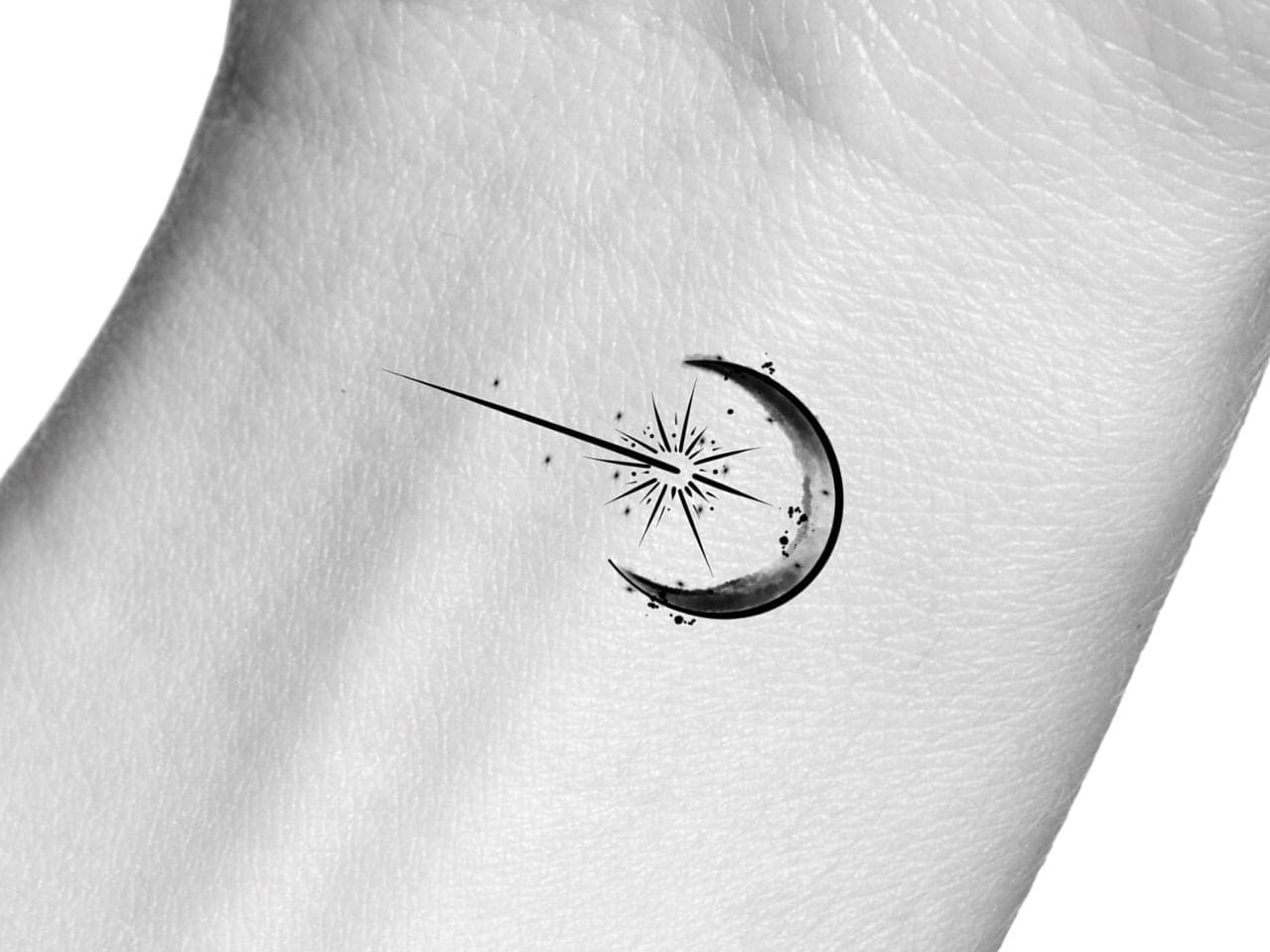 a beautiful shooting star tattoo with a moon
