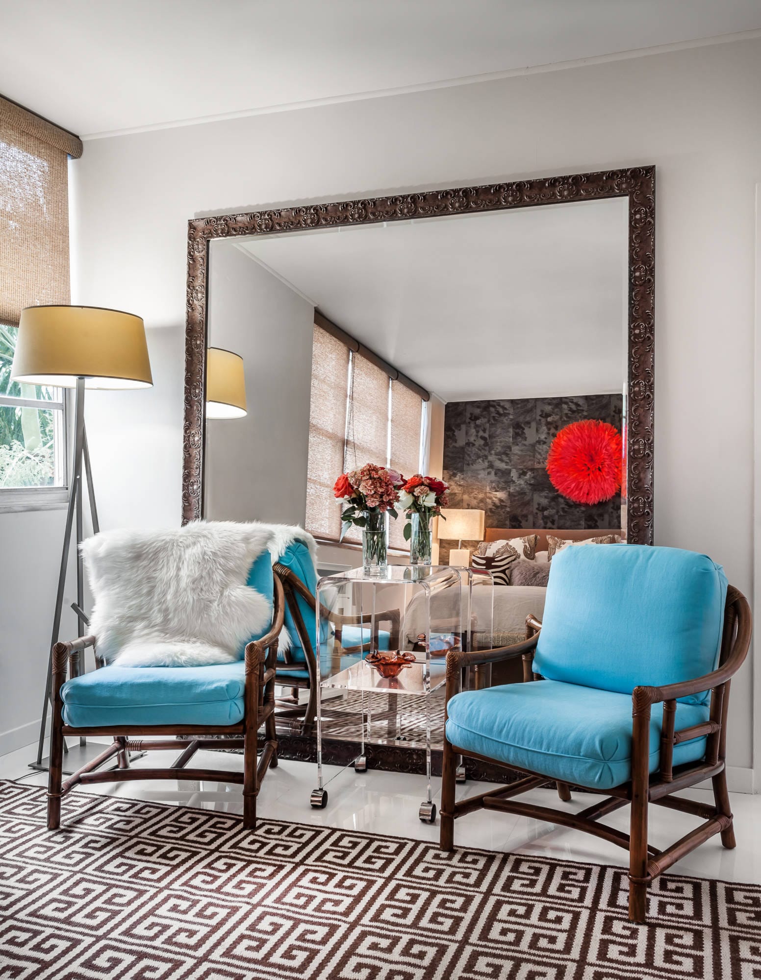 a small living room with large mirrors