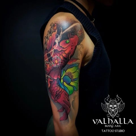 upper arm with japanese koi fish tattoo with watercolor background