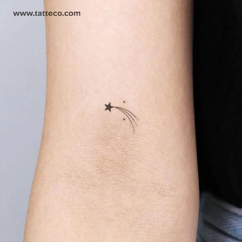 a delicate shooting star tattoo with white ink