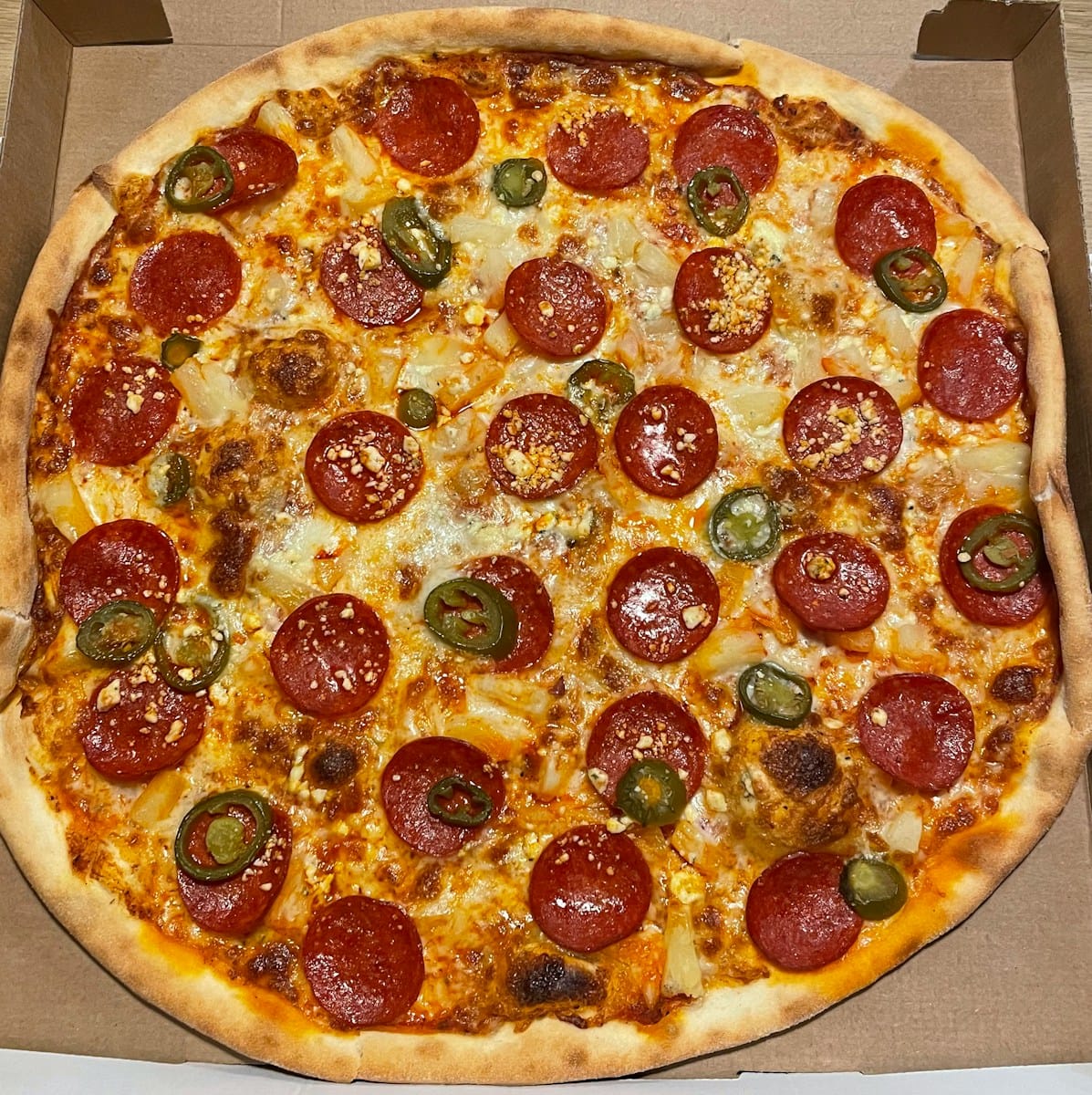 a large pepperoni pizza in a box on a table