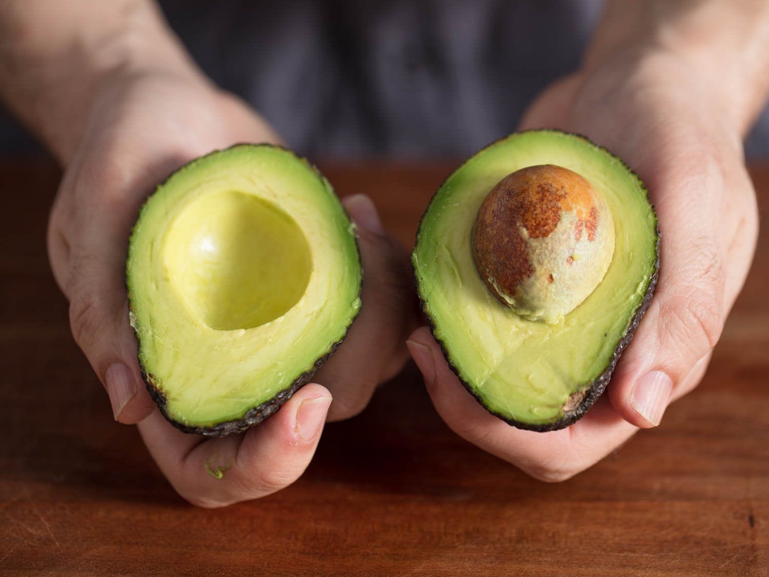 a selection of ripe avocados with a cut avocado