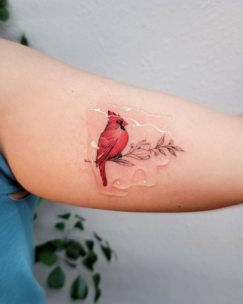 Delicate botanical elements frame this vibrant red cardinal in a stunning forearm piece that captures nature's quiet beauty. The soft, translucent overlay effect creates an almost ethereal quality, as if the bird might take flight at any moment 🕊️ Perfect symbolism for remembrance and hope wrapped in gorgeous artistry.