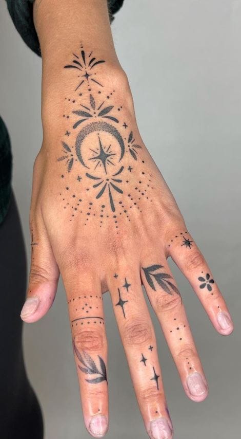 Celestial magic flows across this hand in an intricate constellation of stars, compass roses, and dotwork that transforms everyday gestures into cosmic poetry. The strategic placement extends from wrist to fingertips, creating a living star map that catches light with every movement ✨ Perfect for those who want to carry the universe literally at their fingertips.