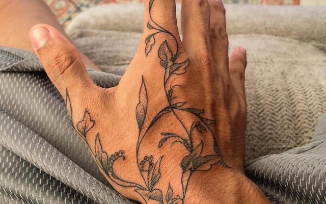 Delicate botanical linework transforms this palm into a living garden, with graceful stems and leaves creating an organic flow across the hand's natural contours. The fine black ink work captures every detail of what appears to be wildflowers or herbs, making it feel like nature itself is growing from within 🌿