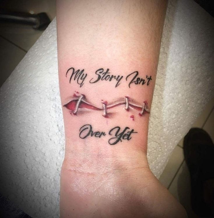 Transforming pain into purpose, this wrist tattoo features delicate stitches that appear to mend the skin while declaring 