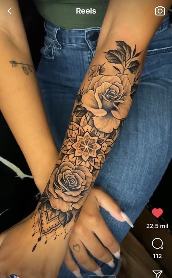 Delicate roses bloom alongside intricate mandala work in this stunning forearm piece that seamlessly blends botanical beauty with geometric precision. The artist's masterful shading technique brings incredible depth to each petal while ornate dotwork details cascade toward the wrist, creating a sleeve that's both feminine and bold 🌹