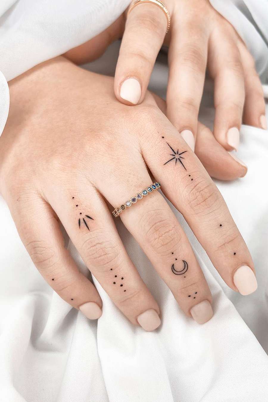 Delicate celestial symbols dance across these fingers like a constellation map written in ink ✨ The minimalist black linework creates an enchanting collection of stars, crescents, and cosmic dots that transform everyday gestures into mystical moments. Perfect for those who want to carry a piece of the universe with them wherever their hands may wander.
