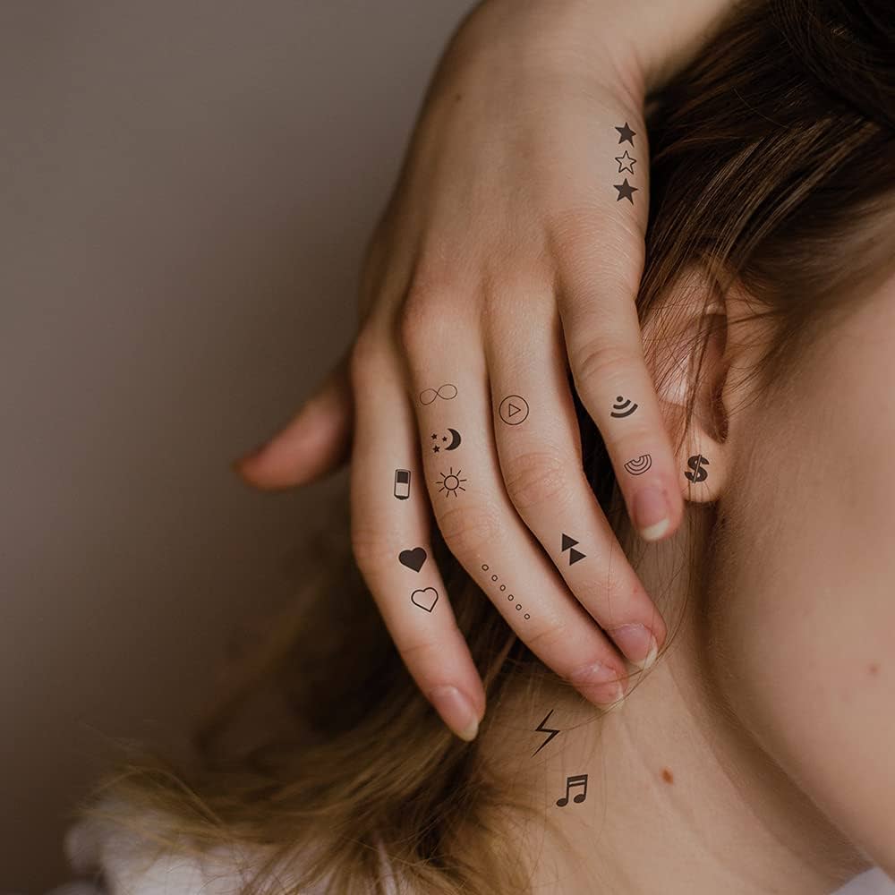 Scattered across fingers and hand like a personal constellation, these delicate micro tattoos create a whimsical story in miniature symbols ✨ From celestial stars to tiny hearts, infinity signs, and musical notes, each small design feels like a secret code written in ink. The placement transforms everyday gestures into moments of artistic expression, with every movement revealing new details of this charming collection.