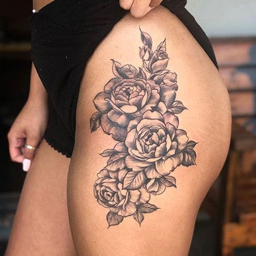 Graceful peonies cascade down the thigh in this stunning black and gray masterpiece, where delicate petals seem to dance with natural movement. The artist's skillful shading creates incredible depth and dimension, making each bloom appear almost three-dimensional against the skin. A perfect example of how floral tattoos can be both feminine and bold 🌸