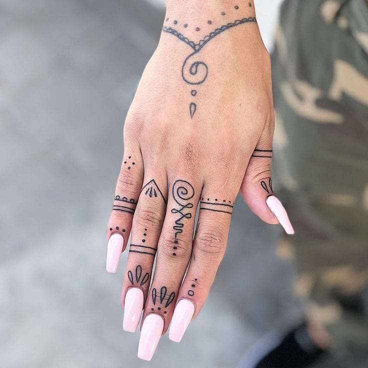 Delicate linework transforms this hand into a canvas of mystical symbolism, with geometric bands wrapping around each finger like ancient rings and celestial dots dancing across the skin. The spiral motif on the back of the hand creates a mesmerizing focal point, while minimalist designs on each digit tell their own tiny stories ✨