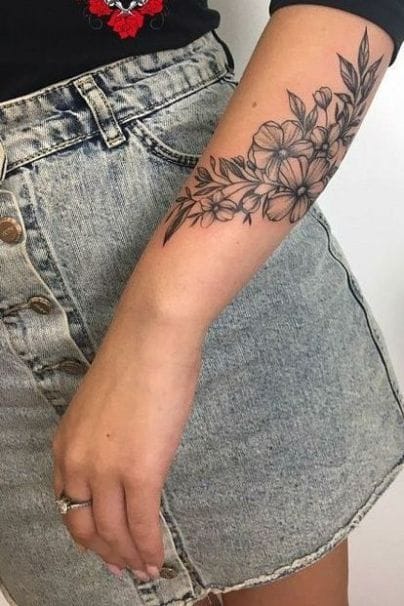 Delicate hibiscus blooms cascade down this forearm in stunning black and grey linework, creating an effortless flow that perfectly complements the natural curve of the arm. The botanical details are rendered with such precision that you can almost feel the soft petals and see the gentle movement of leaves in a tropical breeze 🌺