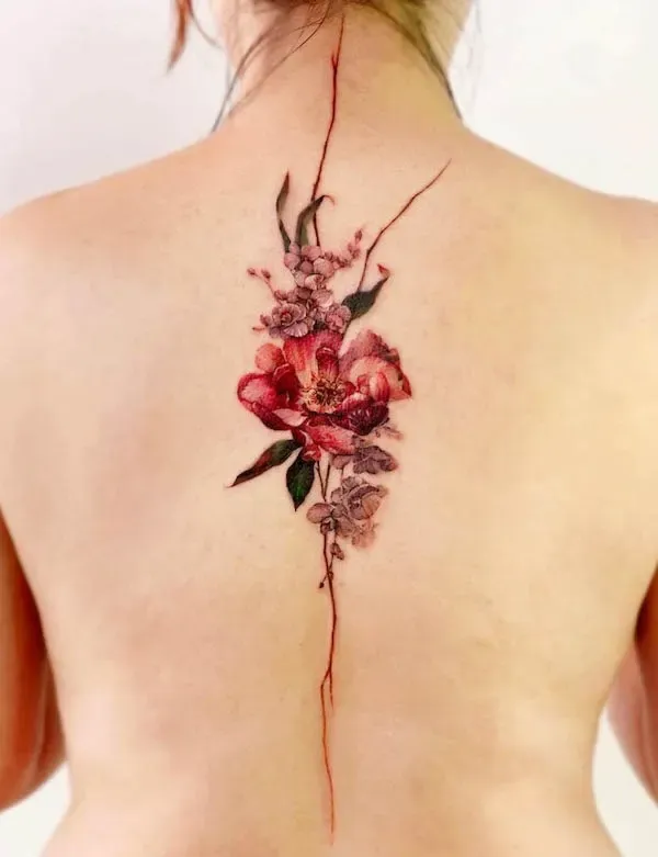 Delicate watercolor blooms cascade down the spine in this breathtaking floral masterpiece, where crimson peonies blend seamlessly with dusty pink botanicals. The artist's skillful use of fine linework and soft color gradients creates an almost painterly effect that follows the natural curve of the back 🌸 A stunning example of how spine tattoos can be both feminine and boldly artistic.