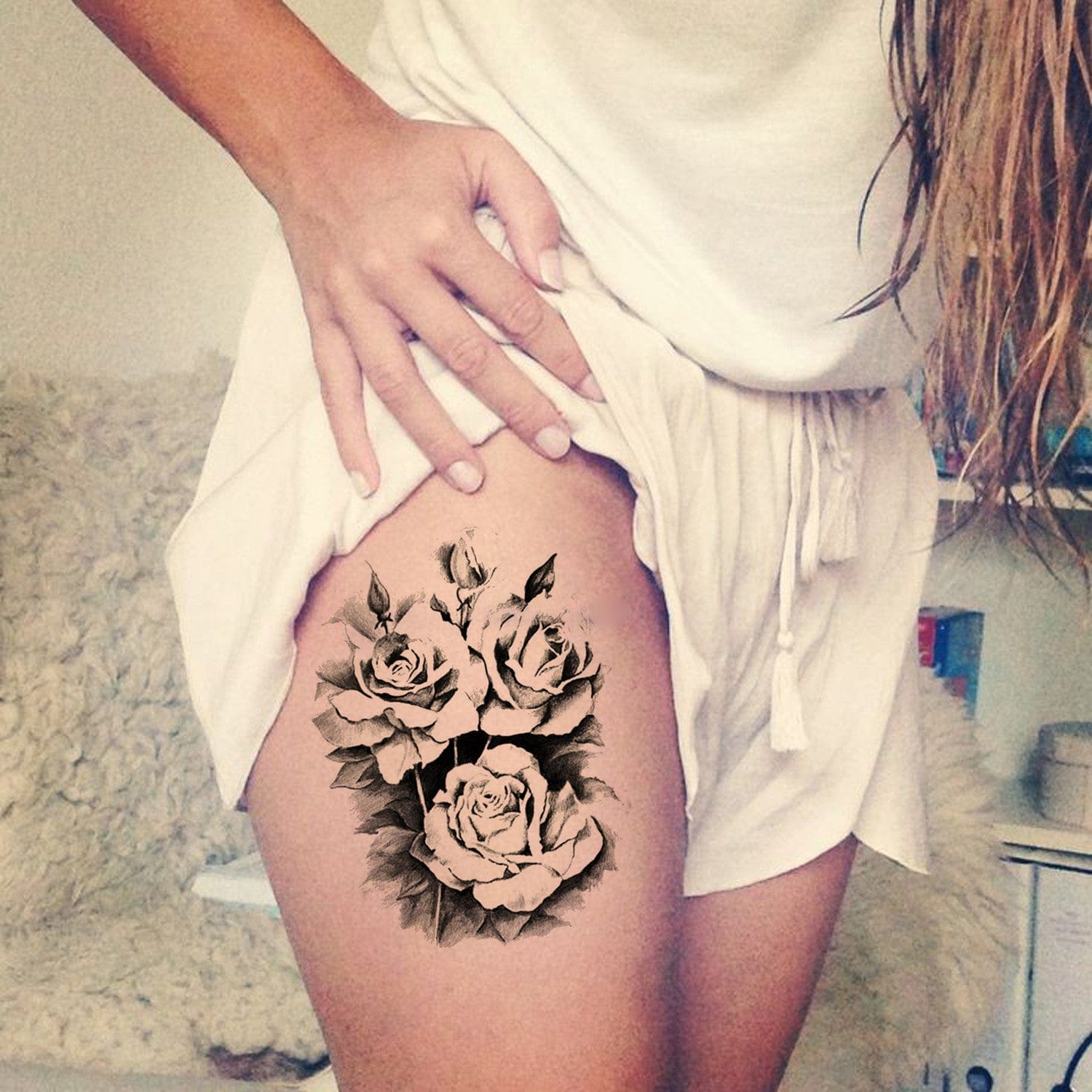 Graceful roses bloom in stunning black and grey realism along this thigh placement, creating an elegant botanical masterpiece that flows beautifully with the body's natural curves. The detailed shading and delicate petal work showcase exceptional artistry, while the strategic positioning allows for both concealment and dramatic reveal. A timeless floral design that perfectly balances femininity with bold statement-making impact 🌹